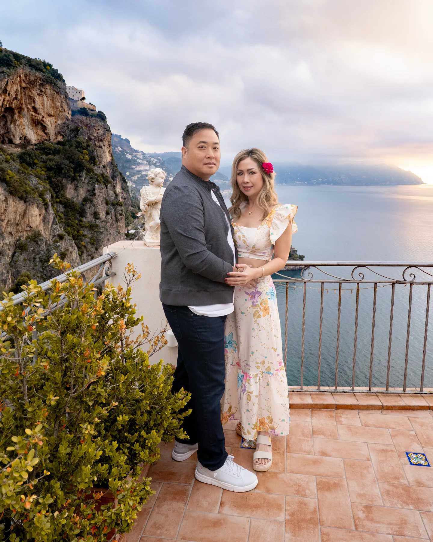 The couple standing together on the villa balcony
