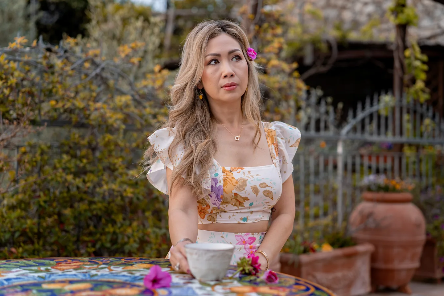 A portrait of Anh with her coffee at the painted table