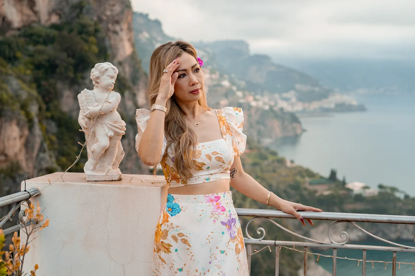 Anh in a floral outfit beside the terrace statue