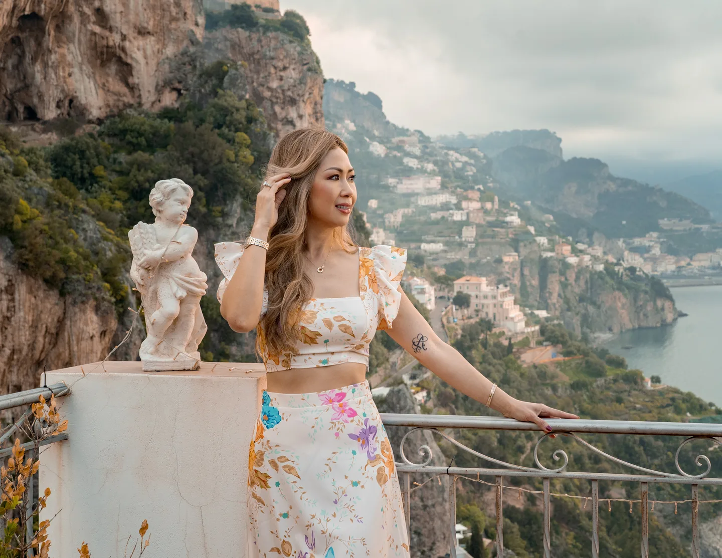Anh standing above the sea with the cliffs behind her