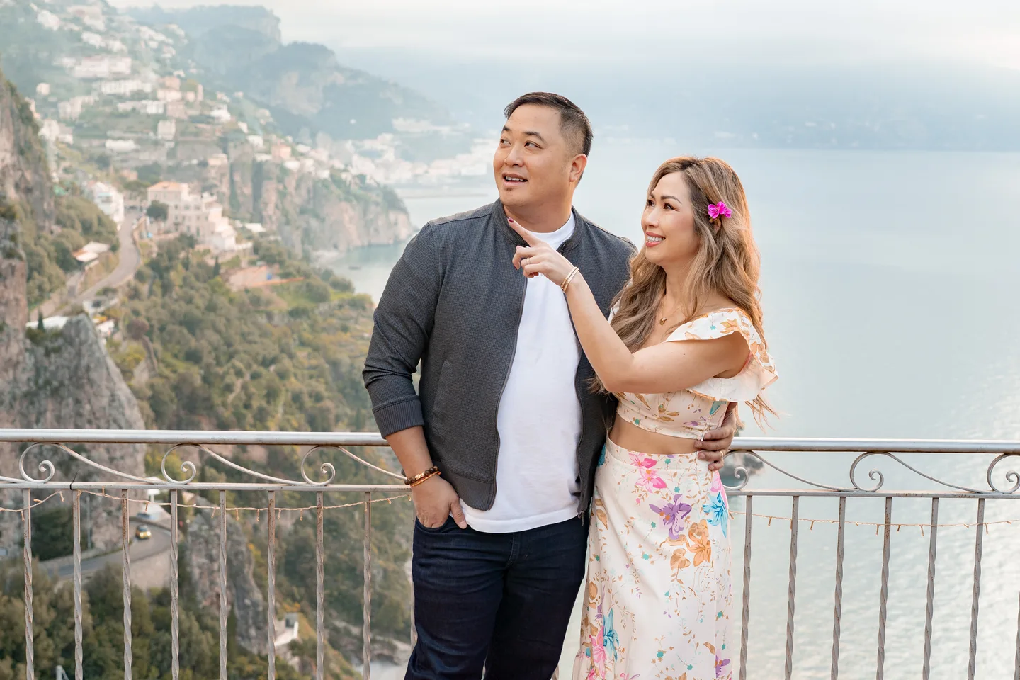 Anh gesturing towards her companion on the terrace