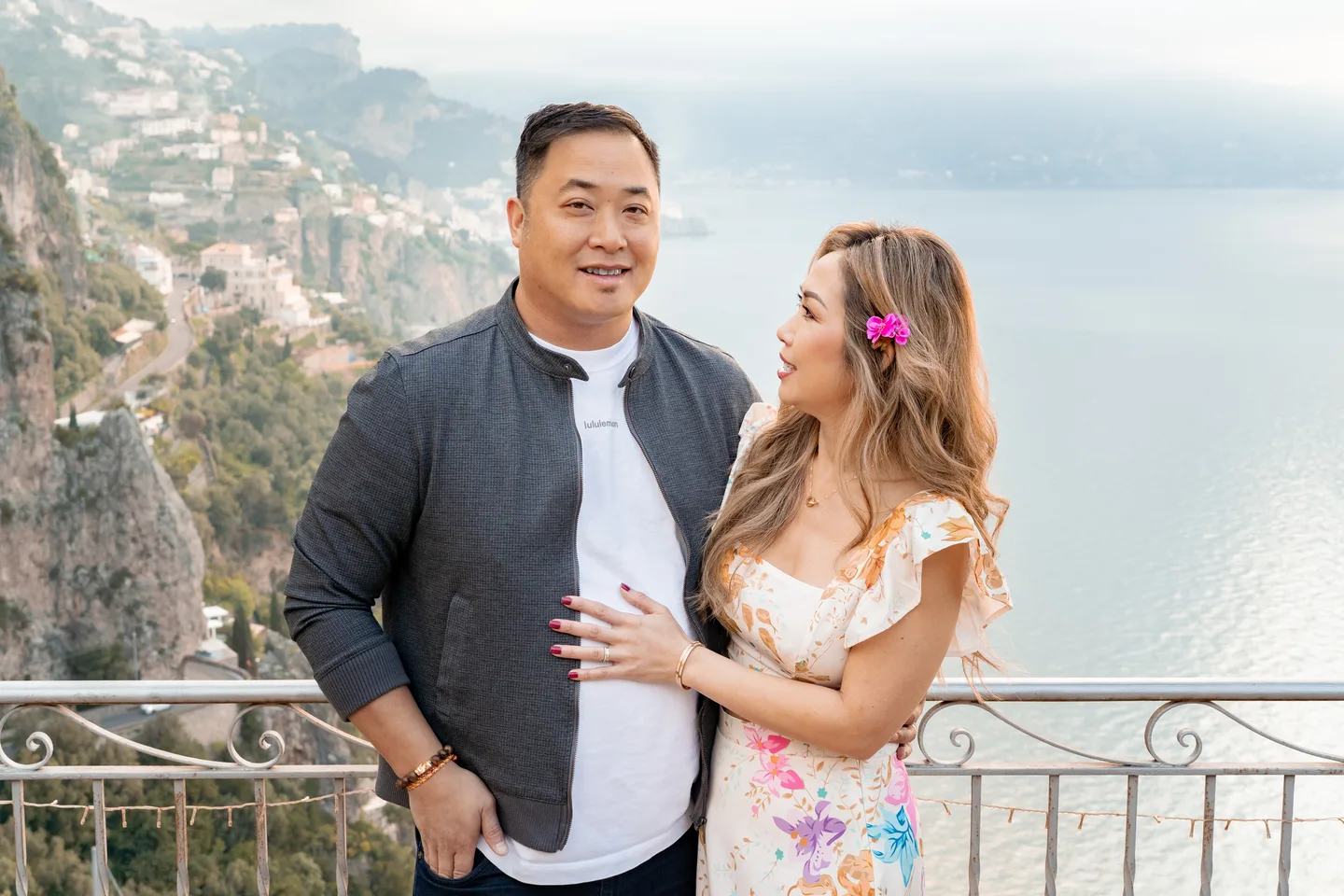 The couple smiling together above the coastal view