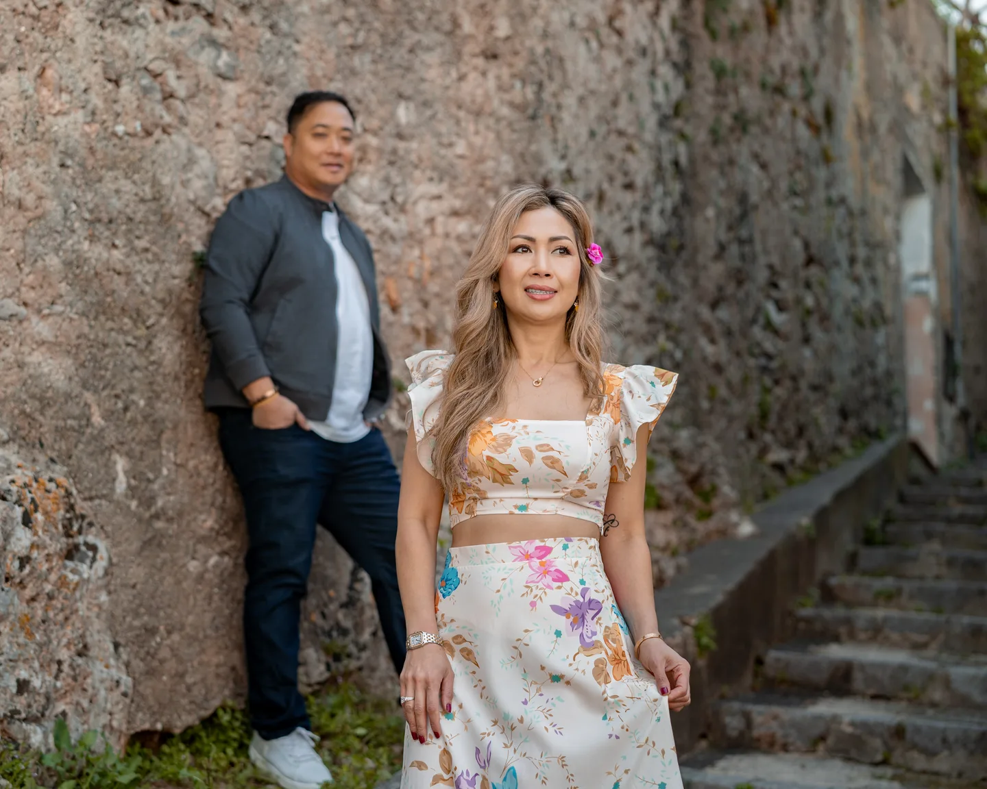 Anh smiling with her companion behind her beside the staircase