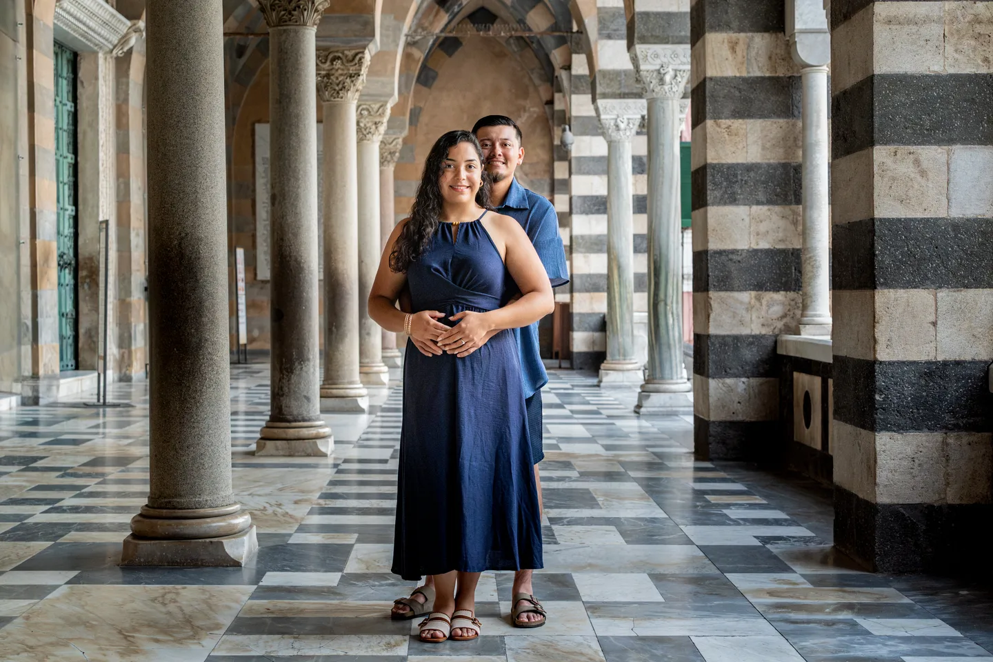 The couple framed by the cathedral columns and patterned floor