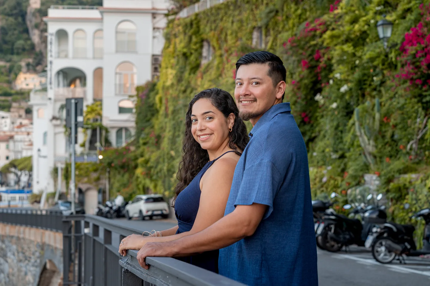 An embrace at the waterfront railing beneath climbing plants