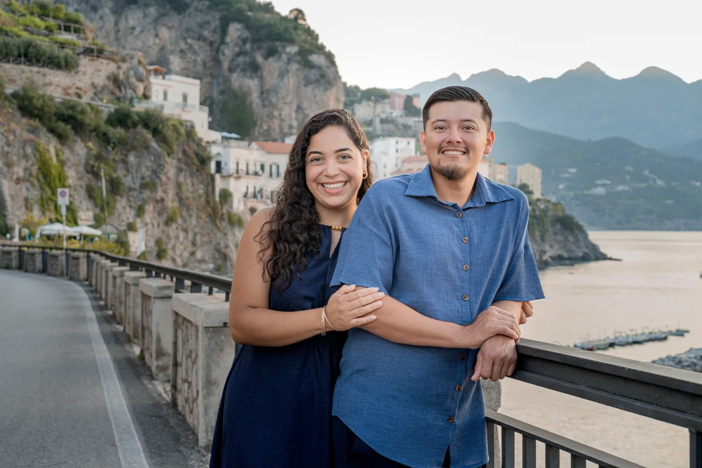 Esmeralda laughing beside her companion on the coastal road