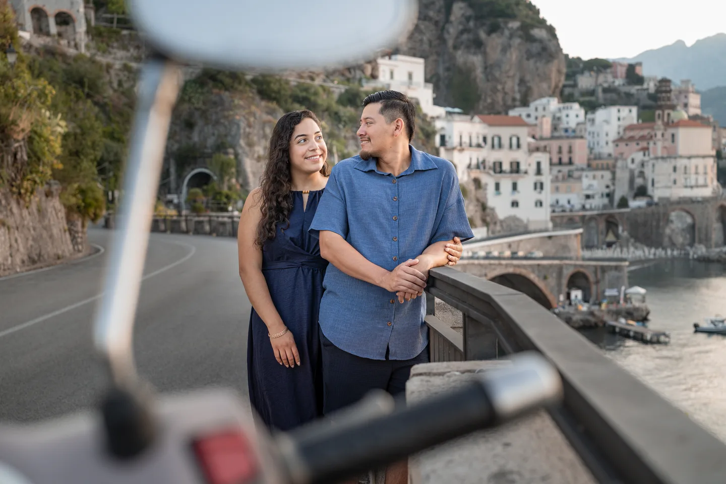 The couple photographed through a scooter mirror beside the coastal road