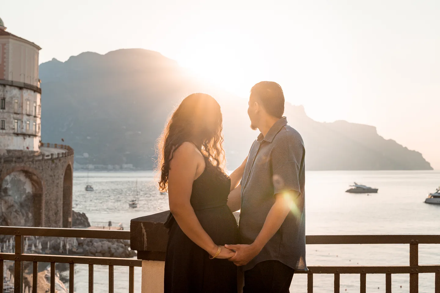 The couple holding hands in a flare of morning sunlight