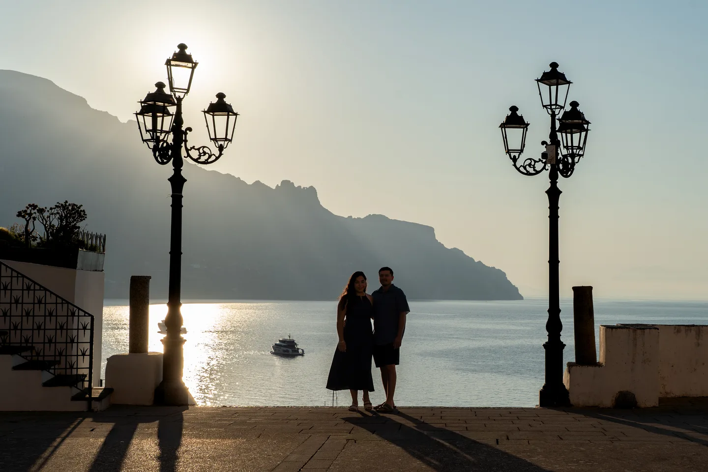 A wide view of the couple and street lamps in the morning light