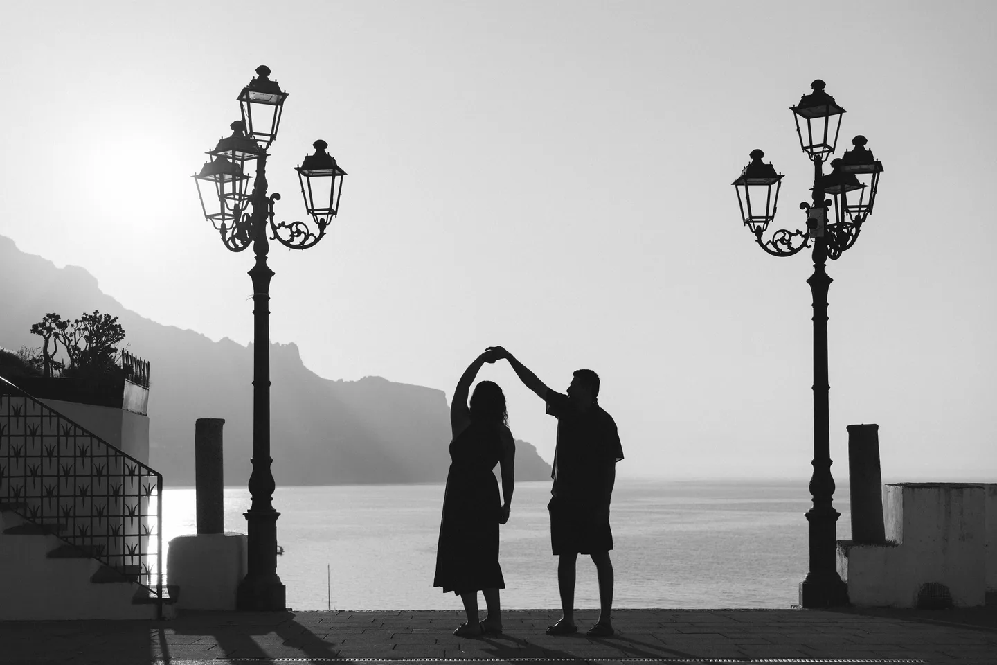 The couple dancing between street lamps in black and white