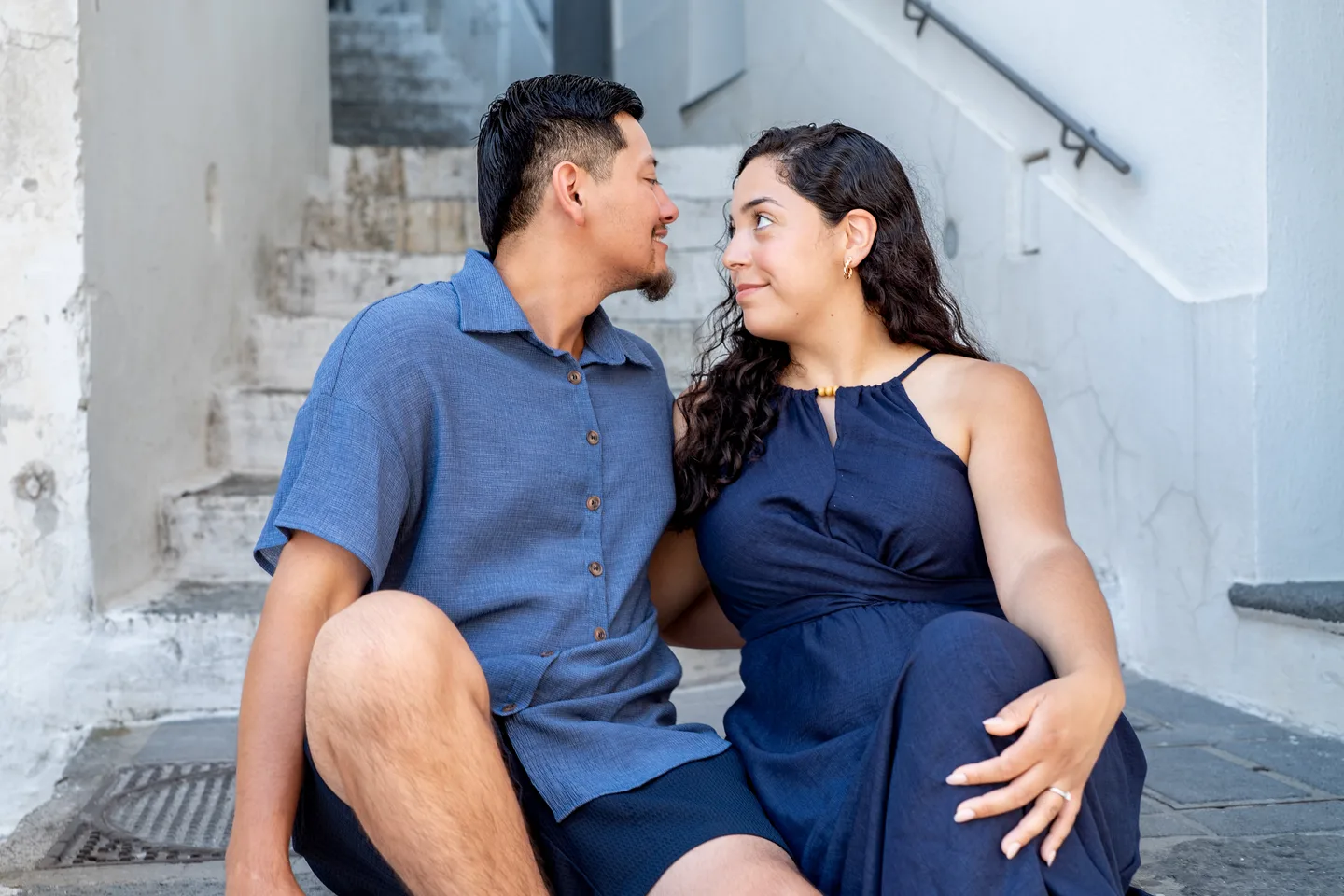 The couple seated together on white village steps