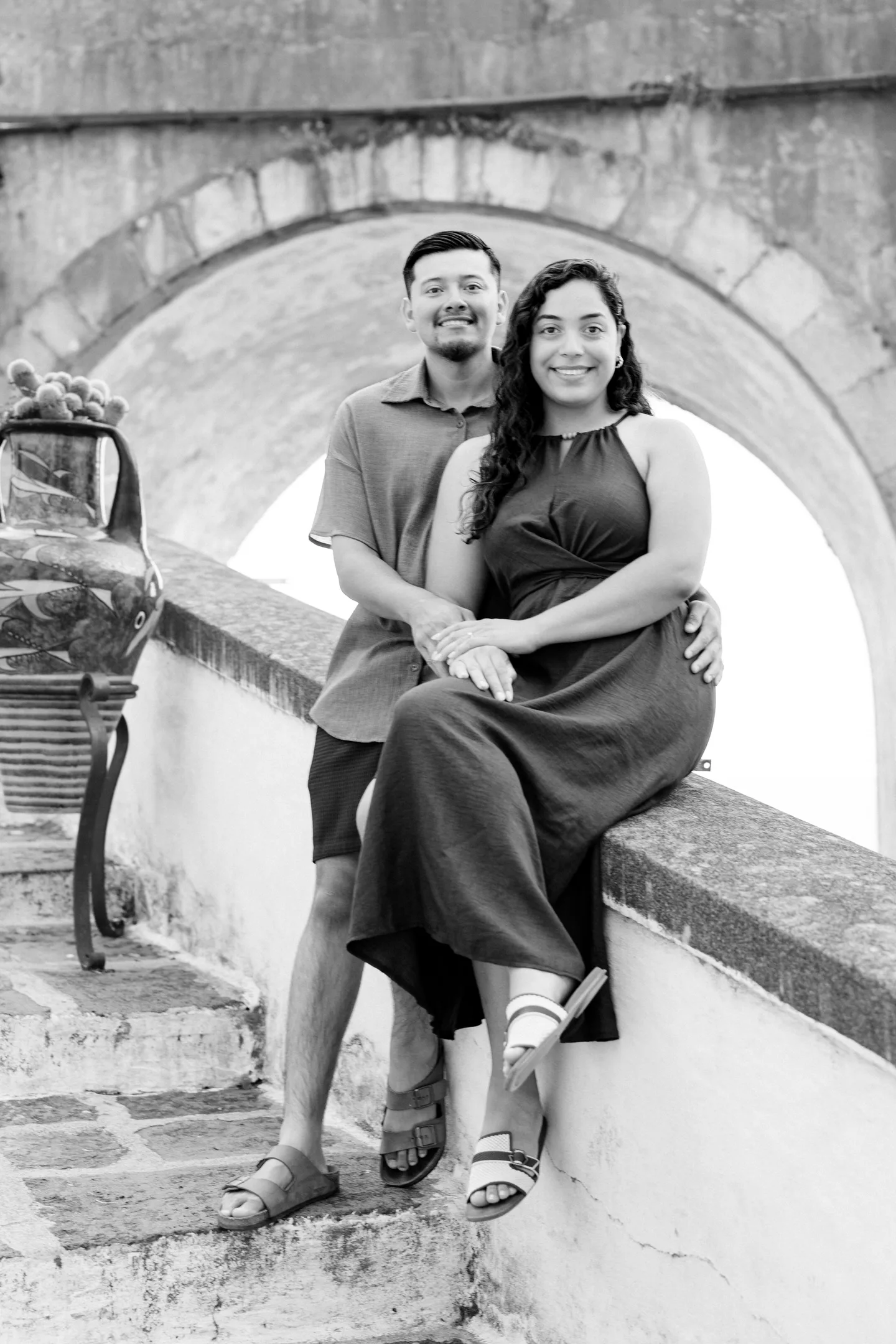 A black-and-white embrace on the stone steps beneath an arch