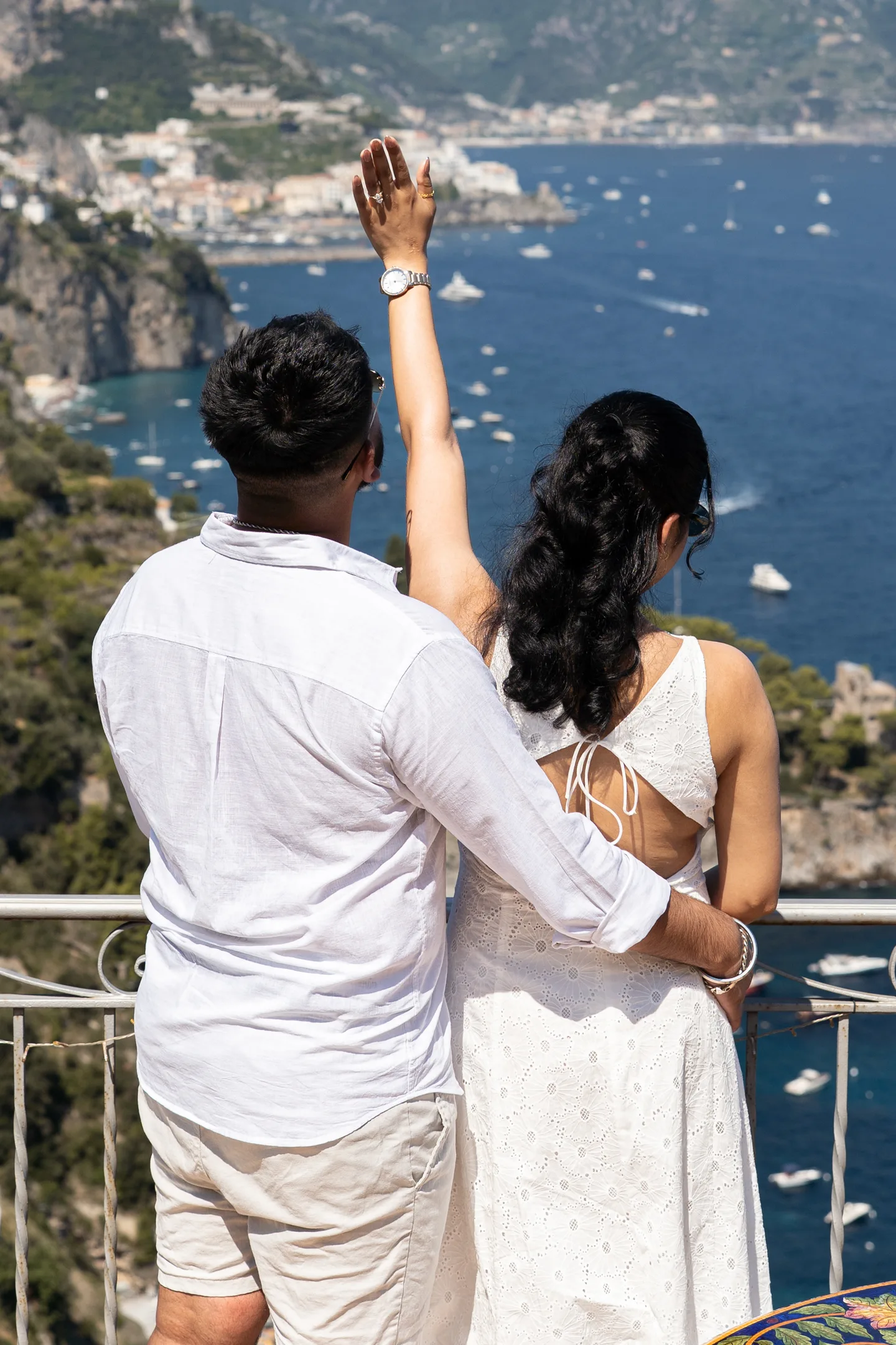 The couple raising a glass towards the sea