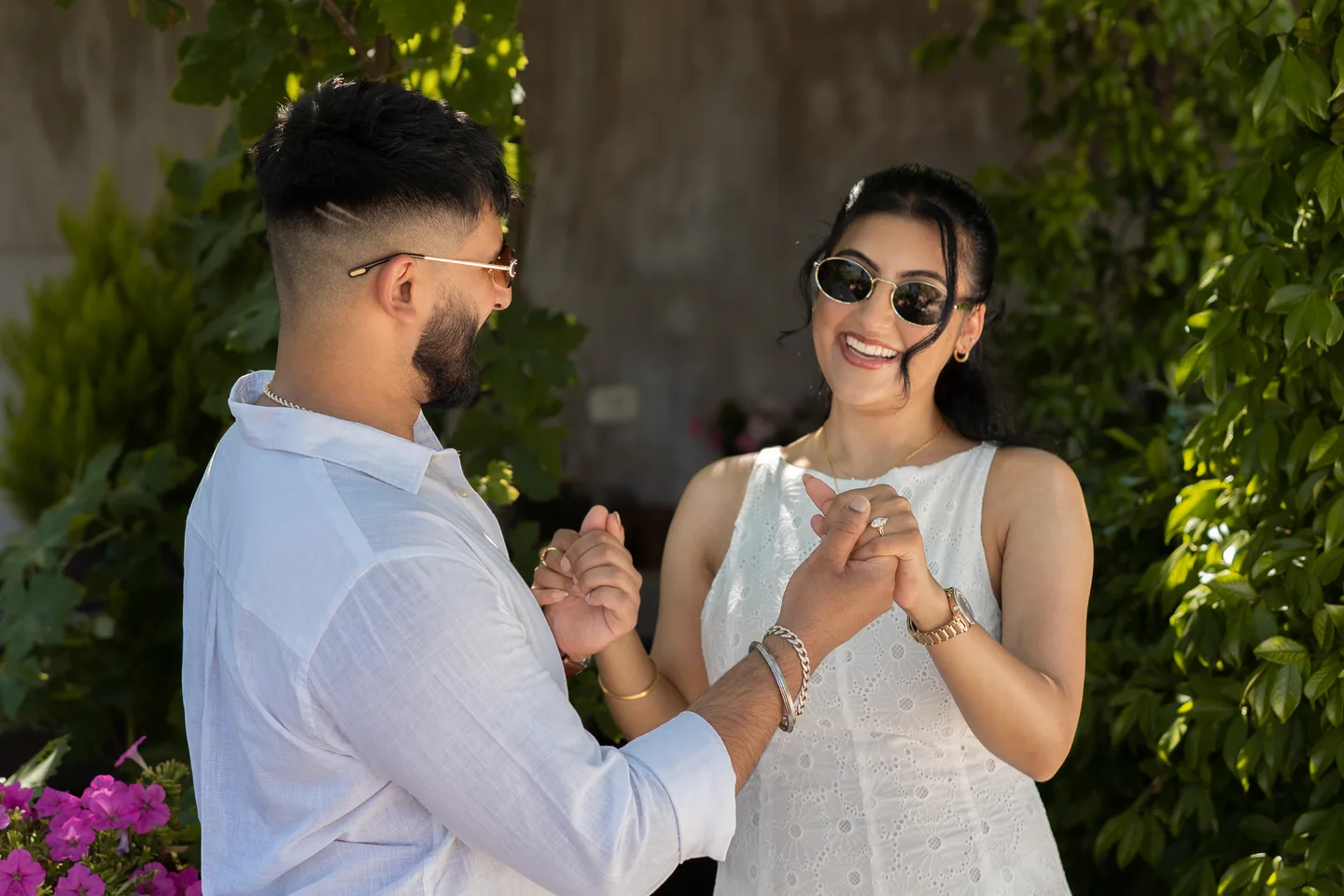 The couple looking at the engagement ring in the garden