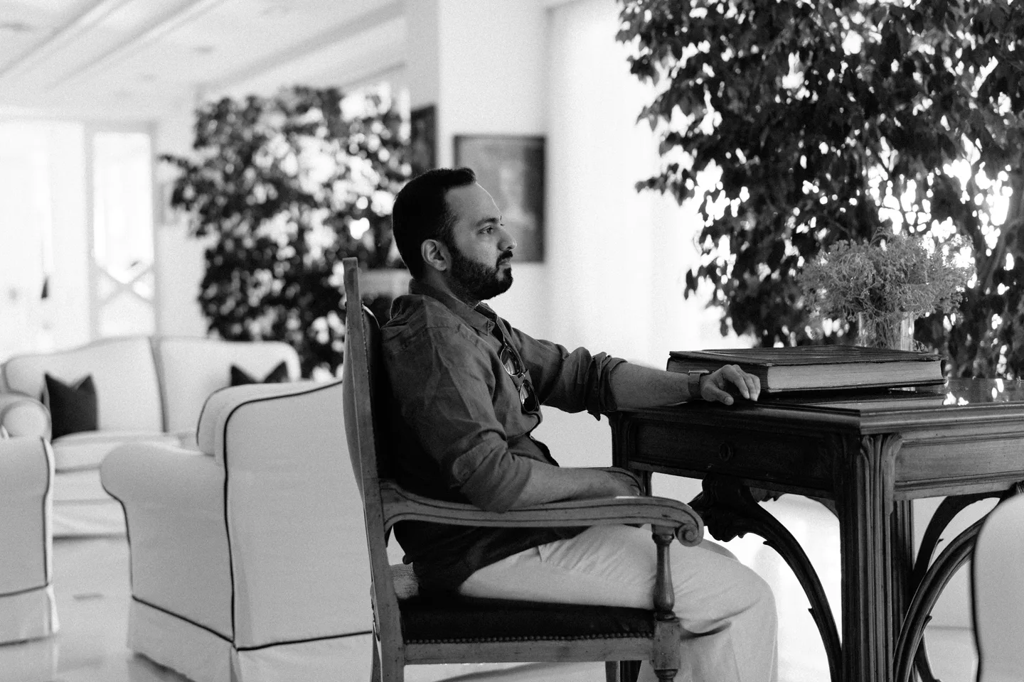 A black-and-white portrait of Jatin in an armchair