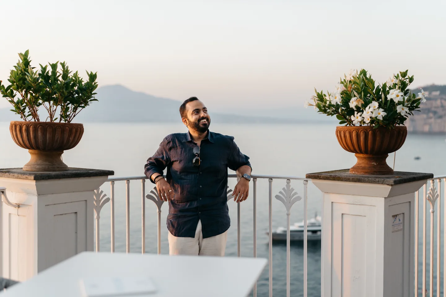 Jatin in a navy shirt between large terracotta planters
