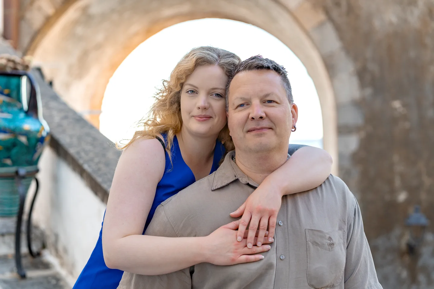 Nathalie embracing her companion beneath an arch