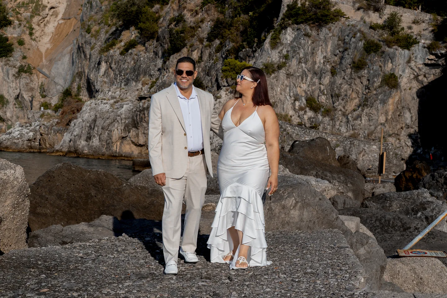 Nilsa looking towards her husband on the waterfront rocks