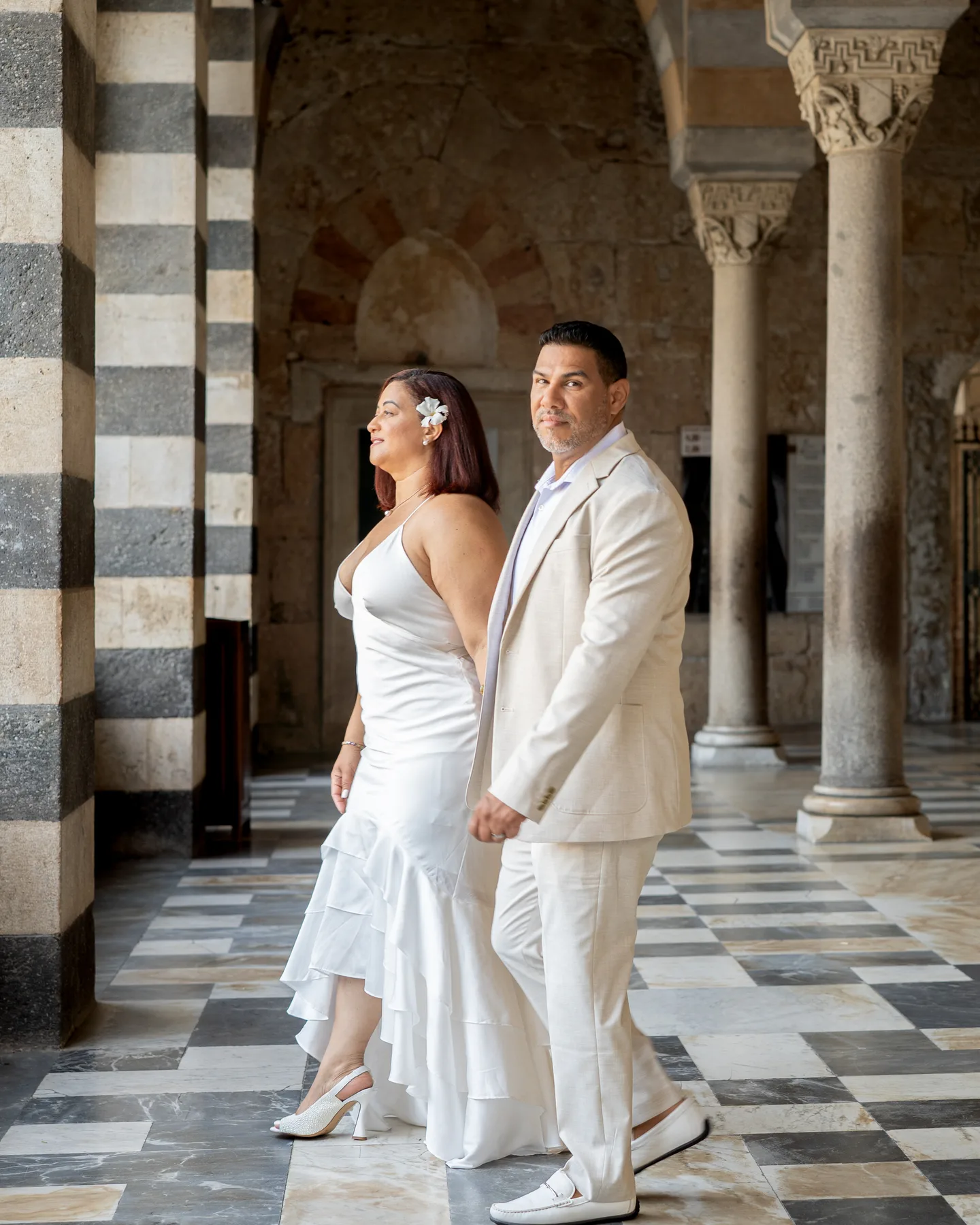 The couple standing between the cathedral’s striped columns