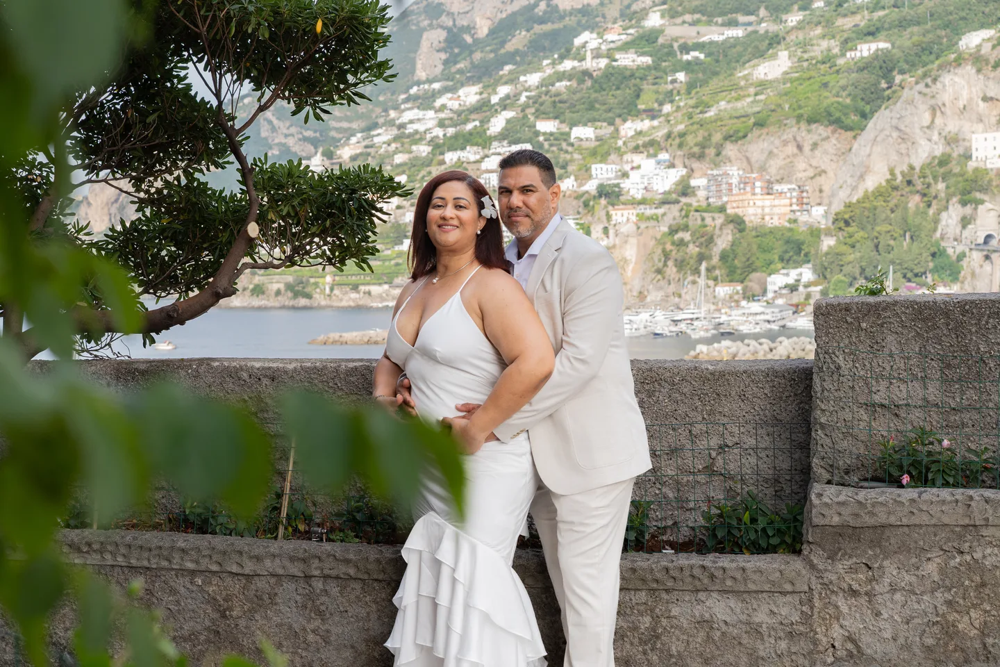 An embrace beneath the trees beside the sea wall