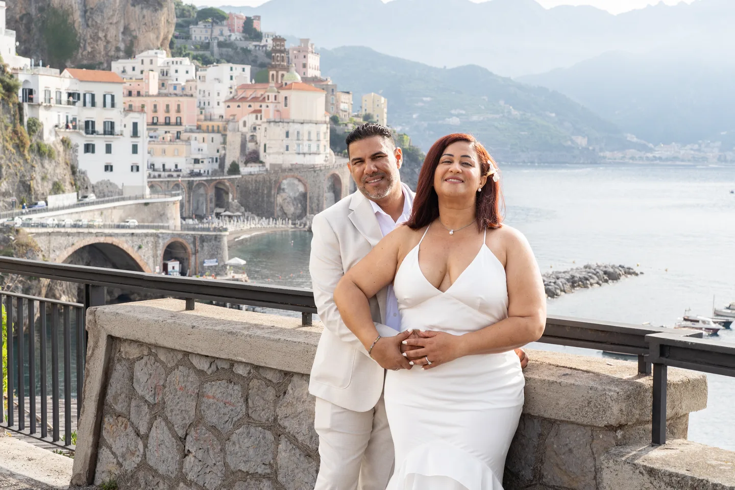 Nilsa smiling in her husband’s arms above Atrani