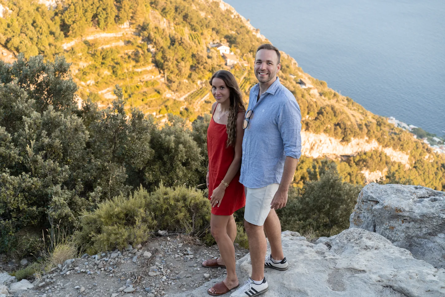 The couple beside the sunlit mountain slope
