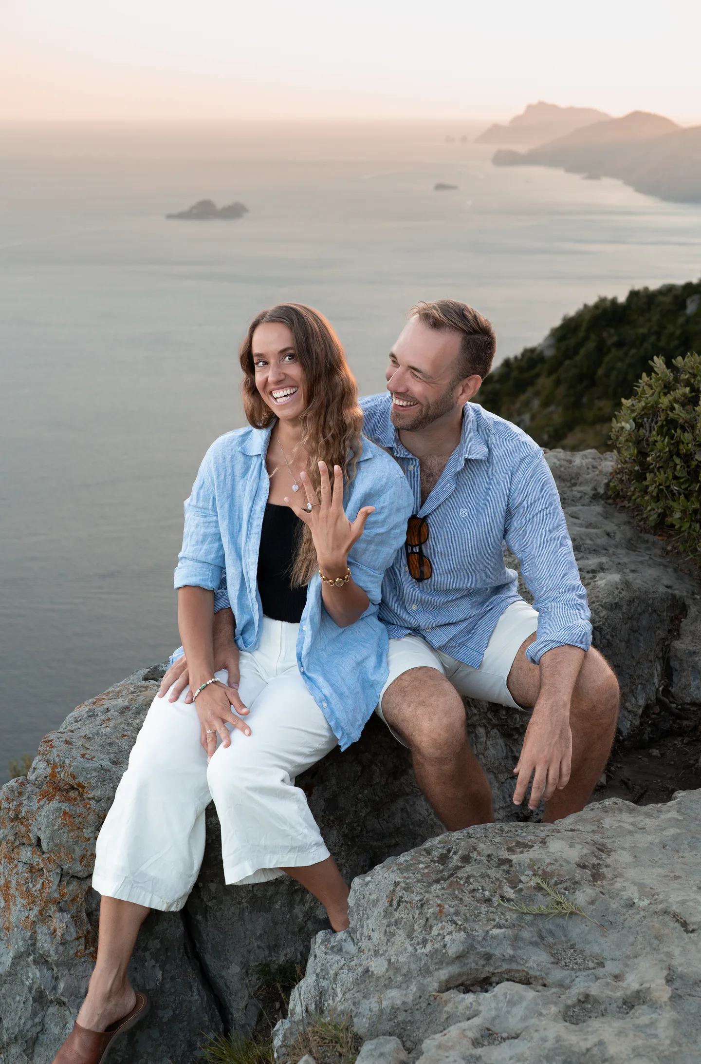 The couple laughing together on the rocks