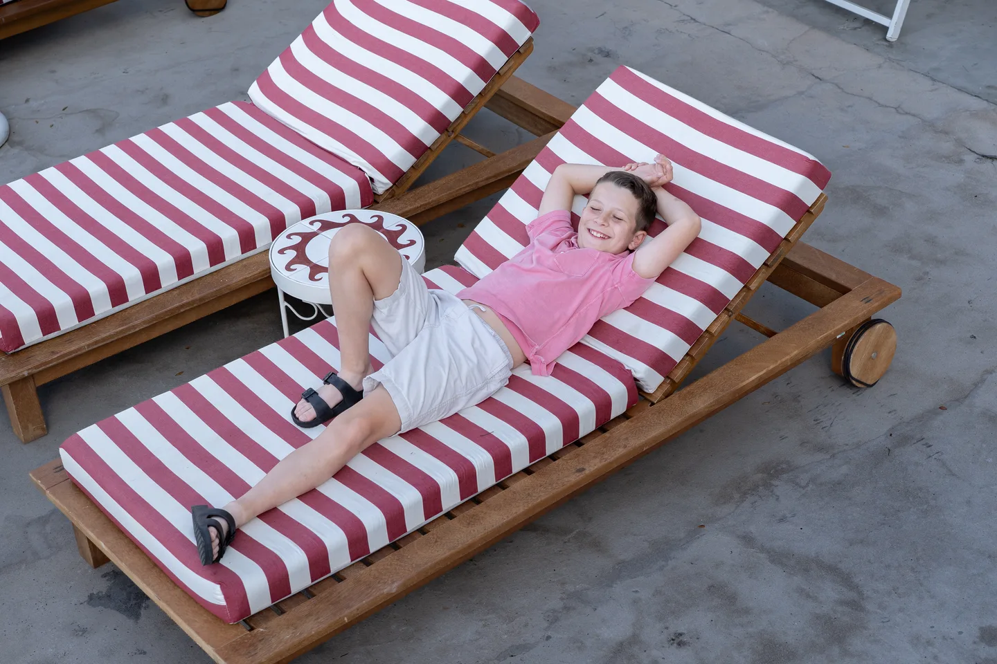 A child relaxing on a striped beach lounger