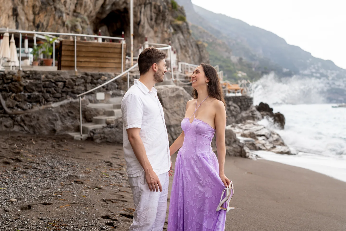 The couple together on the sand beside the rocks