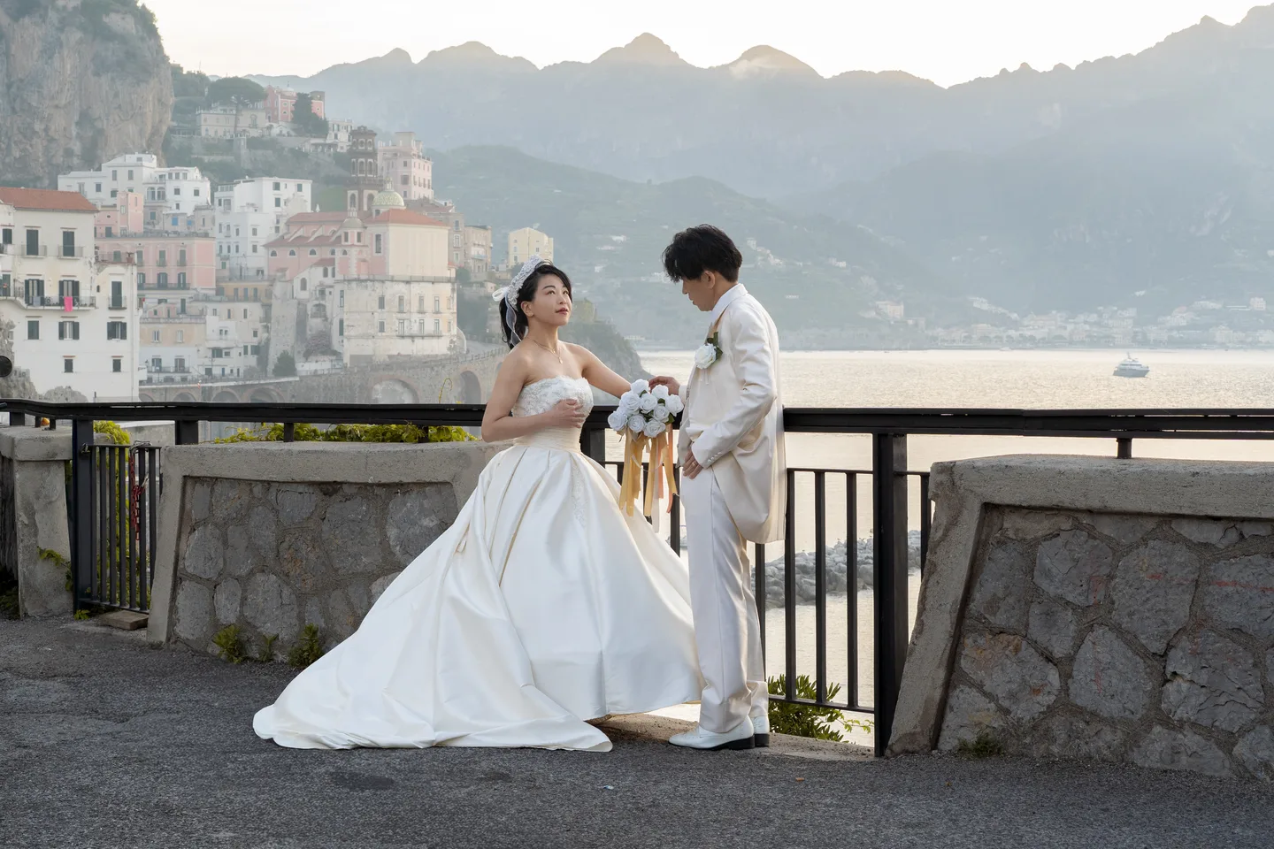 The couple and the sweeping wedding dress above Atrani