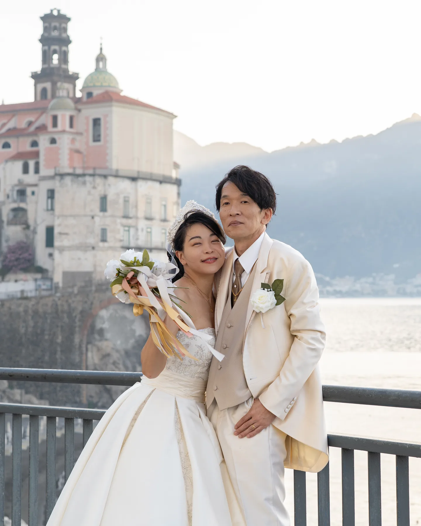 The couple with their bouquet in front of Atrani’s church