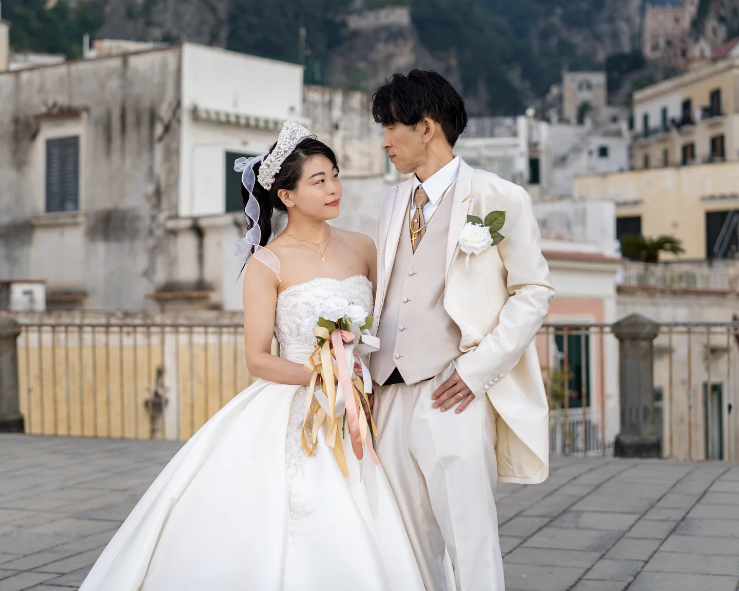 The couple looking down at the wedding dress together