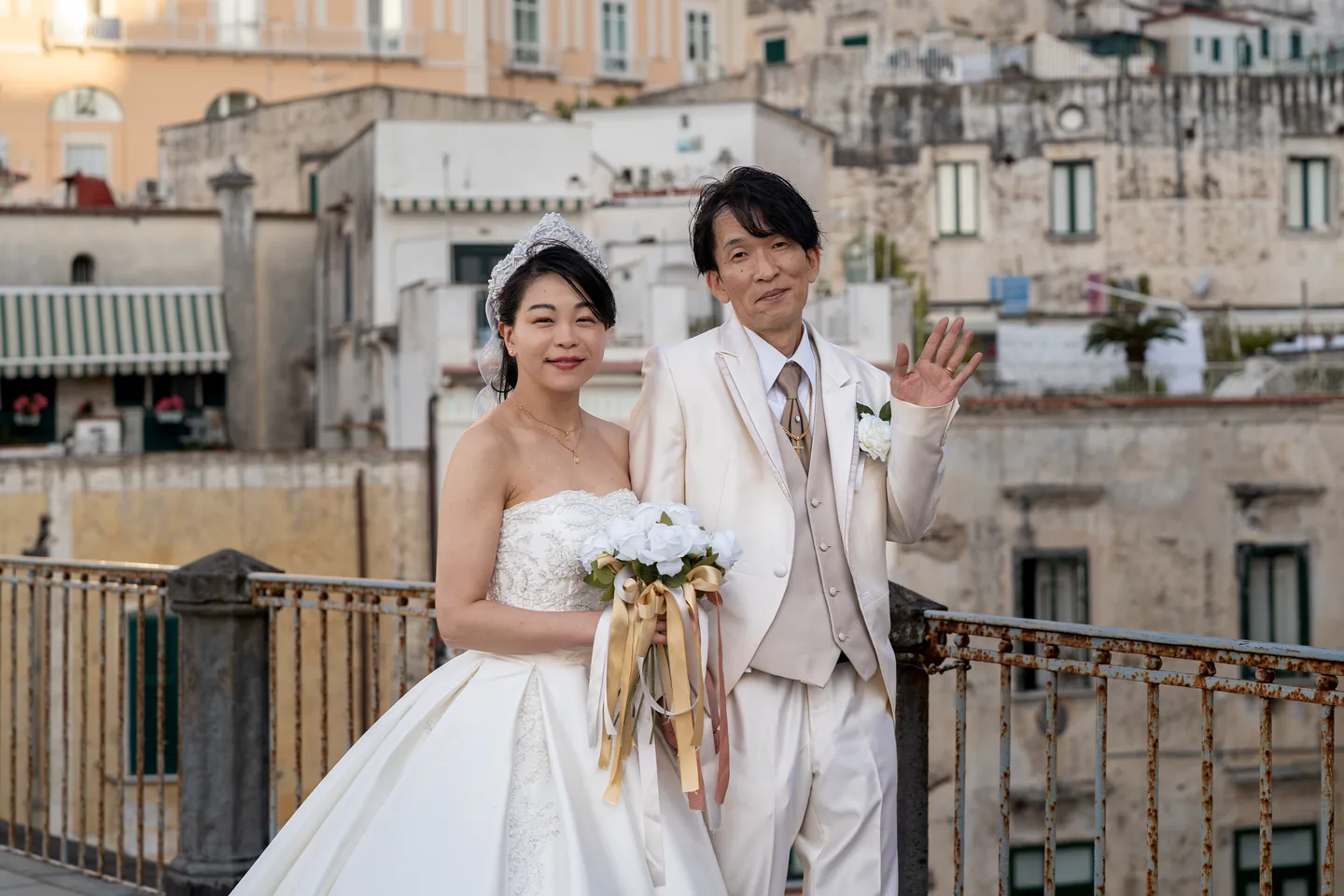 The couple waving to the camera above the village square