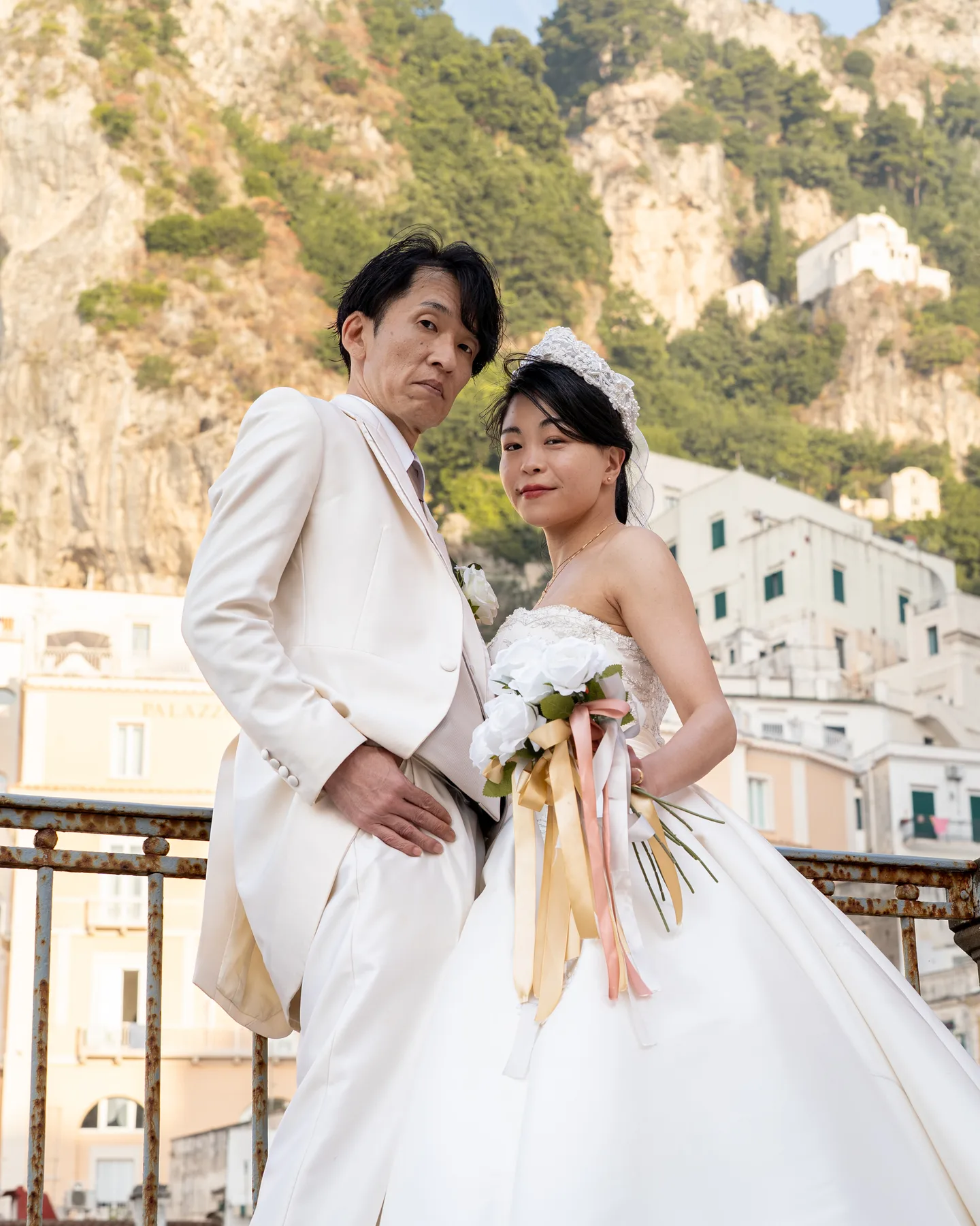The couple with their bouquet against the sunlit hillside