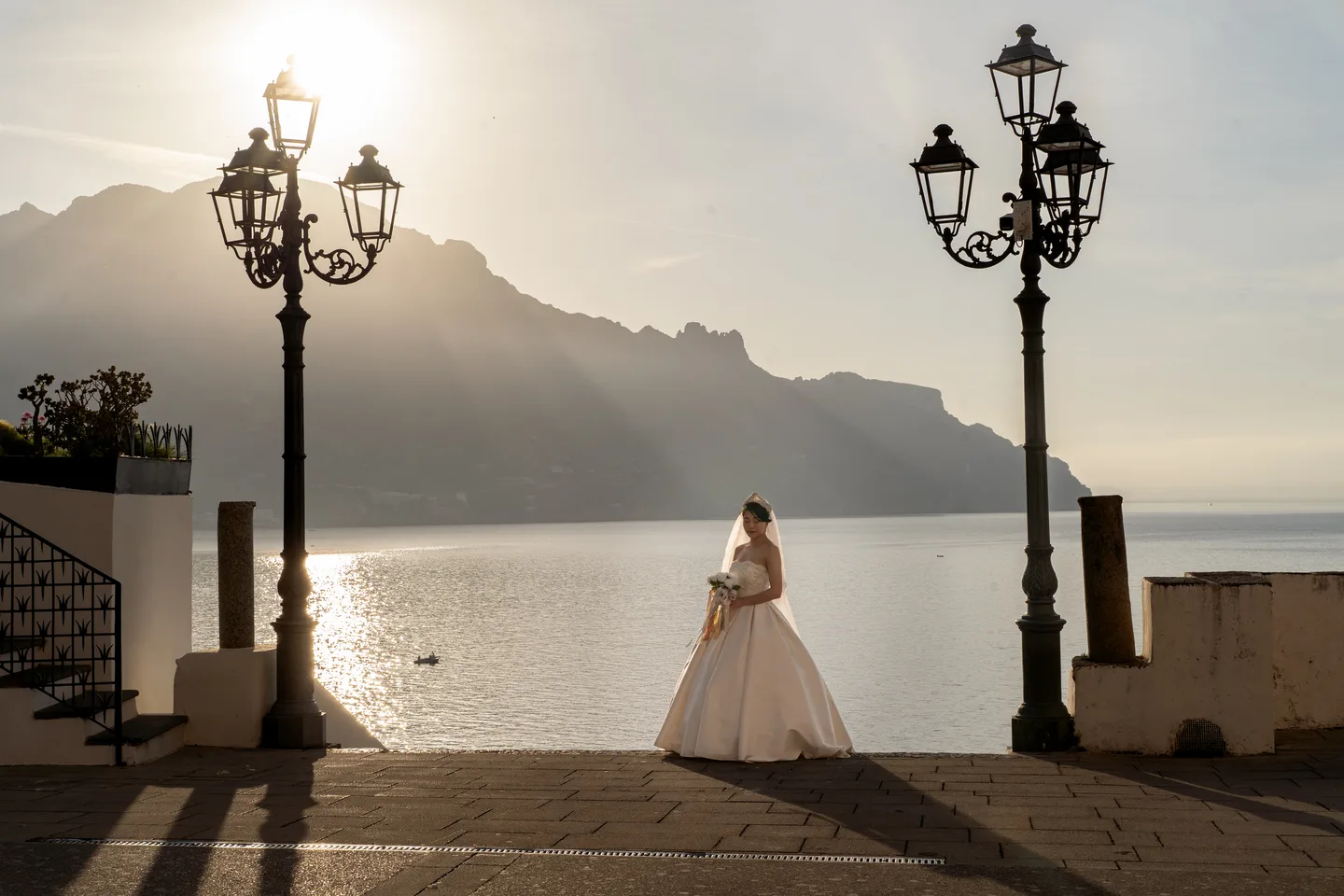 A lone portrait in the wedding dress between seaside street lamps