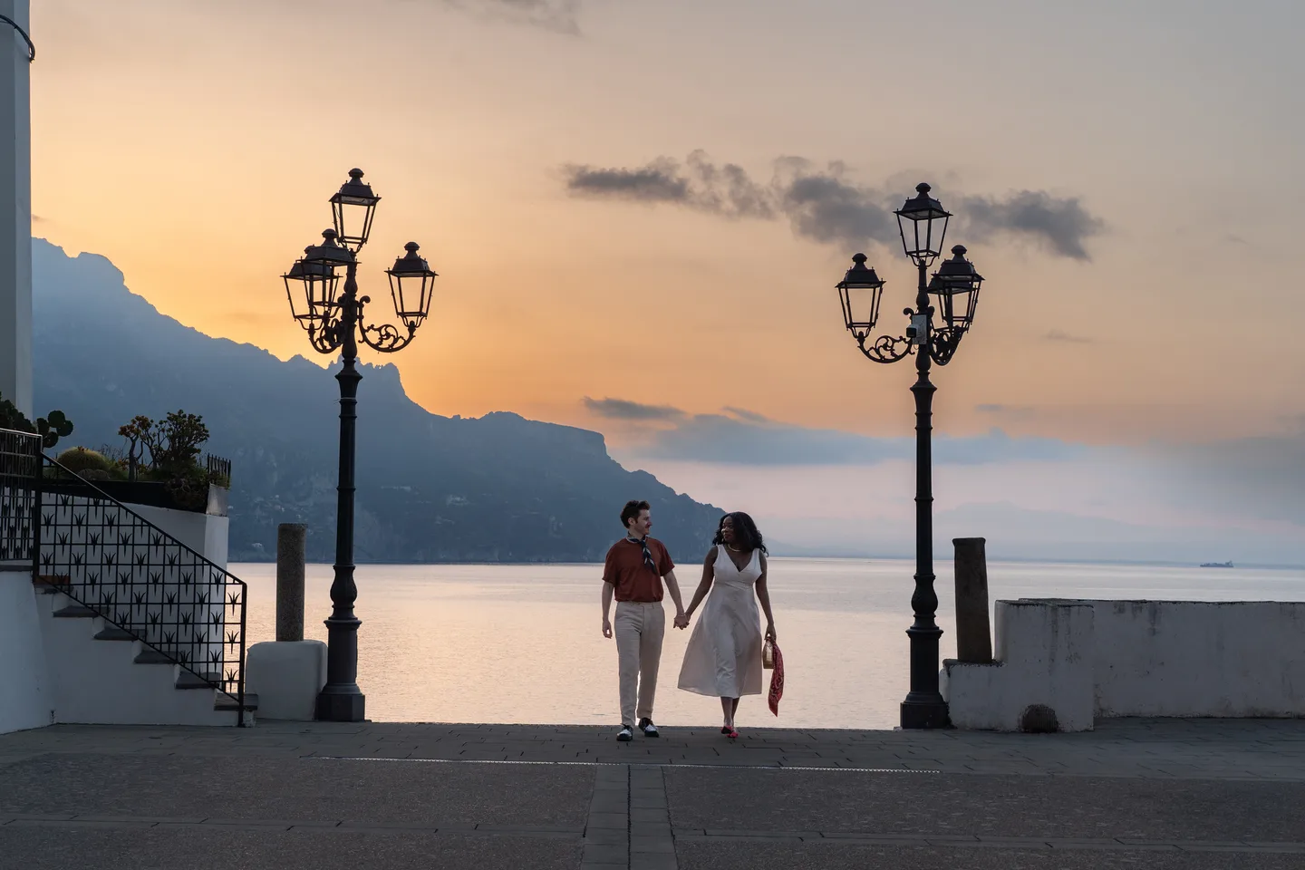 A wide view of the couple between lamps at sunrise