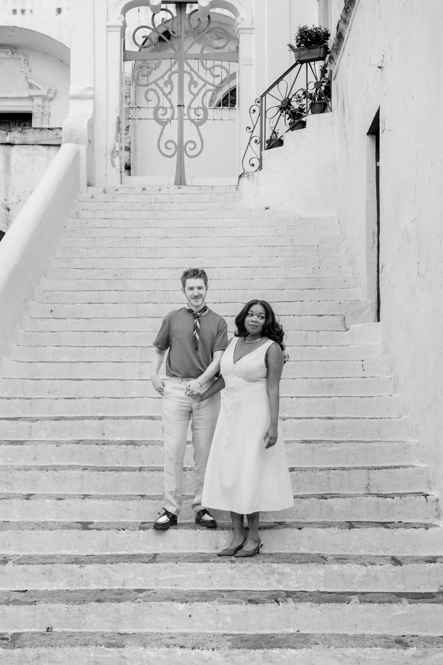 A black-and-white portrait of the couple on a broad white staircase