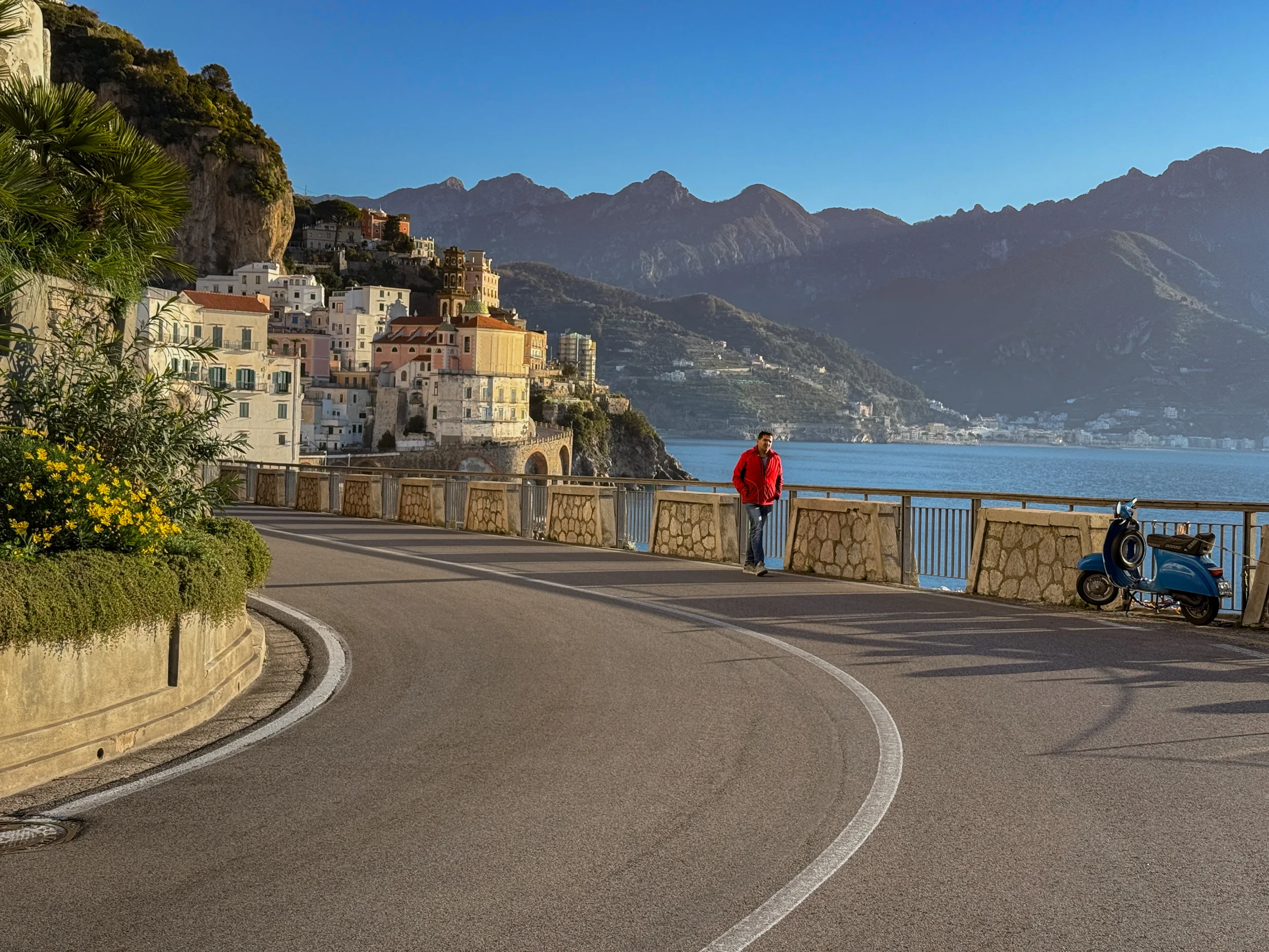 Scooter rider on the Amalfi Coast road with sea panorama